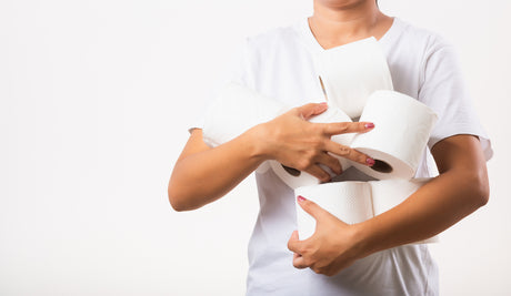 Someone in a white tshirt holding several rolls of toilet paper to help illustrate How Long Before You Poop After Gastric Sleeve