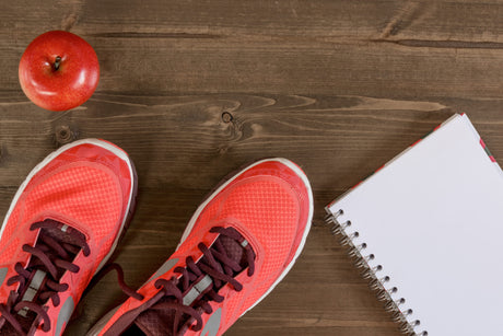 Women's shoes and a notebook for recording sporting achievements to illustrate How to get back on track after bariatric surgery