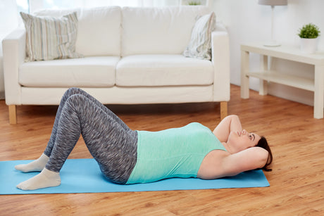 Woman laying on a mat to get ready for an ab crunch to illustrate Toning Exercises After Bariatric Surgery and challenges after weight loss surgery.