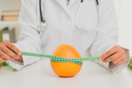 doctor measuring orange to illustrate What Is A Bariatric Doctor