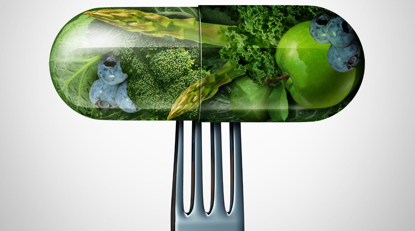 A pill or medicine capsule with fresh fruit and vegetables inside on a fork to help illustrate best vitamins for bariatric patients