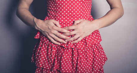 Woman holding her stomach to illustrate no bowel movement after gastric sleeve