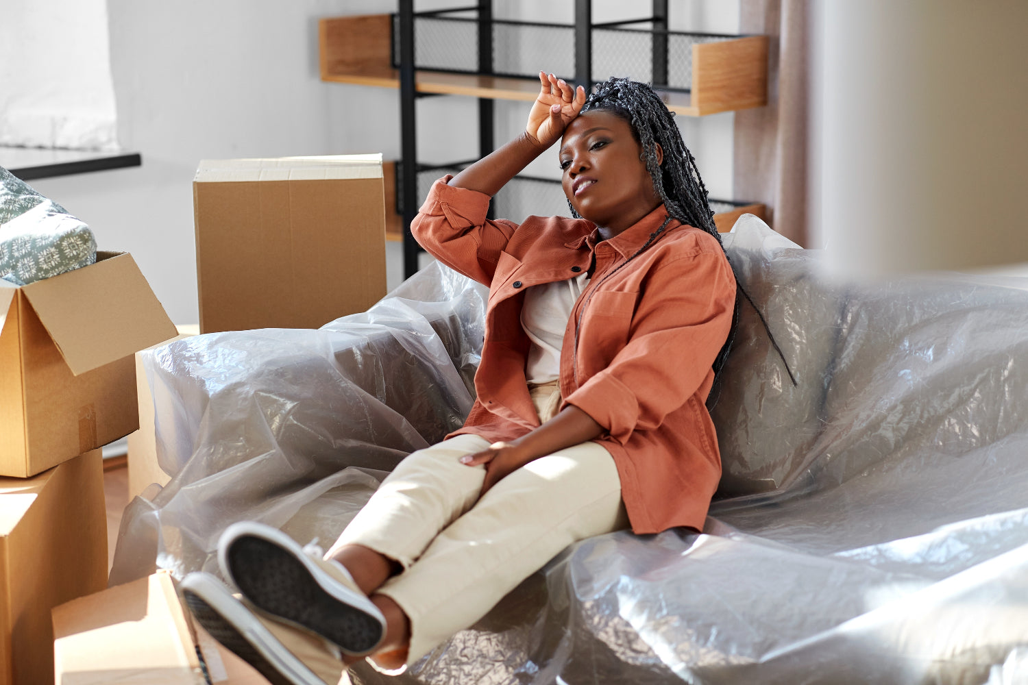An image of a woman sitting on a couch with her feet up and the back of her to forehead to illustrate Best Iron Supplement After Bariatric Surgery and Does Bariatric Surgery Lead to Severe Nutrient Deficiencies