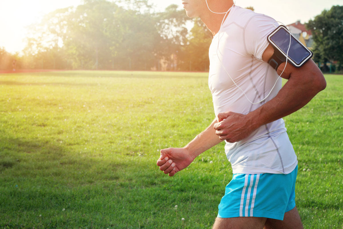Image of a torso of a man running while listening to music to help illustrate how to stay motivated for exercise.