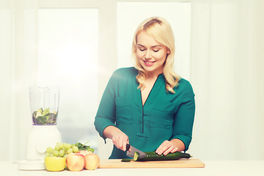Smiling woman with blender cooking food.