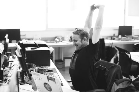 man-stretching-in-office