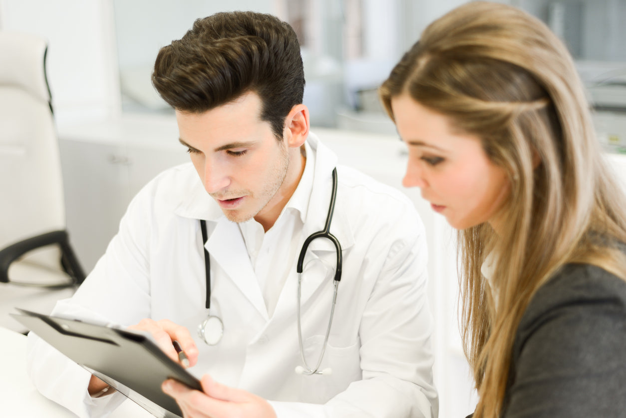 Doctor explaining diagnosis to female patient to help illustrate bariatric surgical procedures