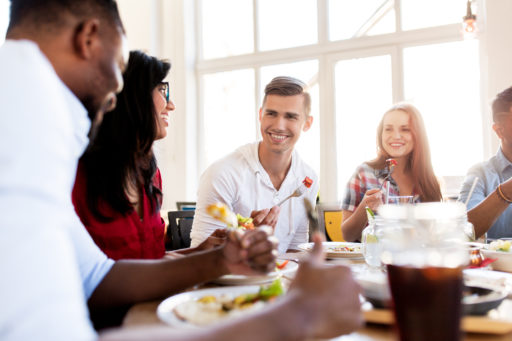 A happy family eating together at a restaurant to show bariatric friendly restaurants