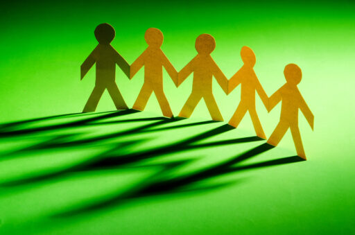 Paper cutout of figures "holding hands" to illustrate Benefits of Support Groups During Weight Loss