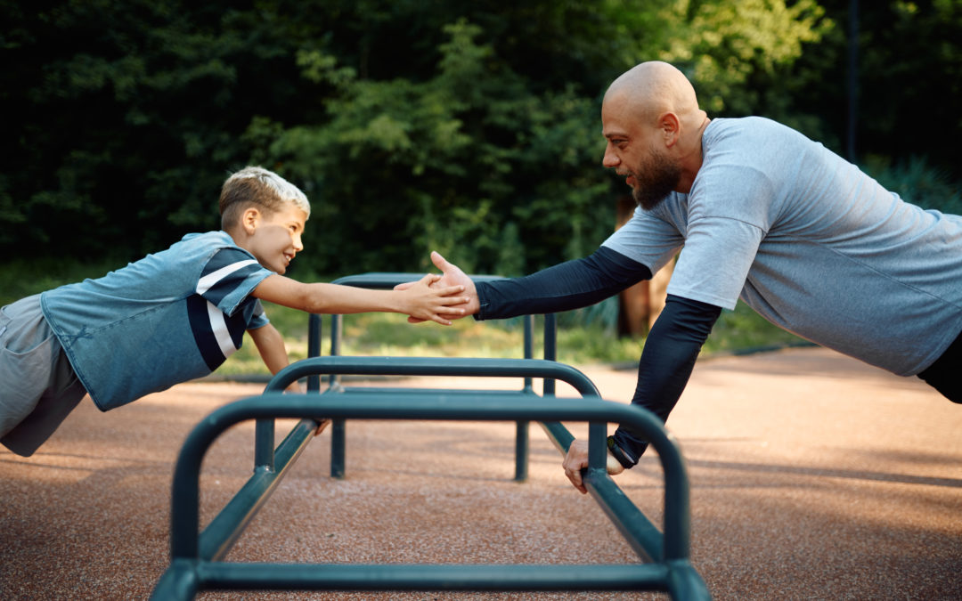 Father and boy, push-up exercise on playground to illustrate Childhood Obesity Prevention
