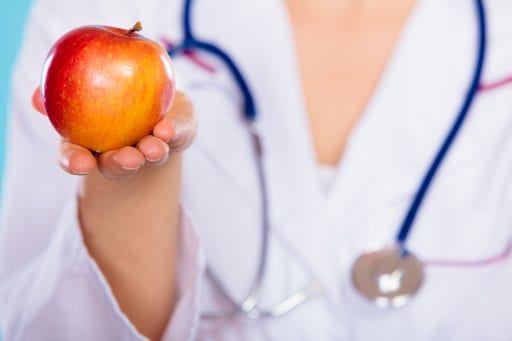 Nutritionist holding apple in her hand