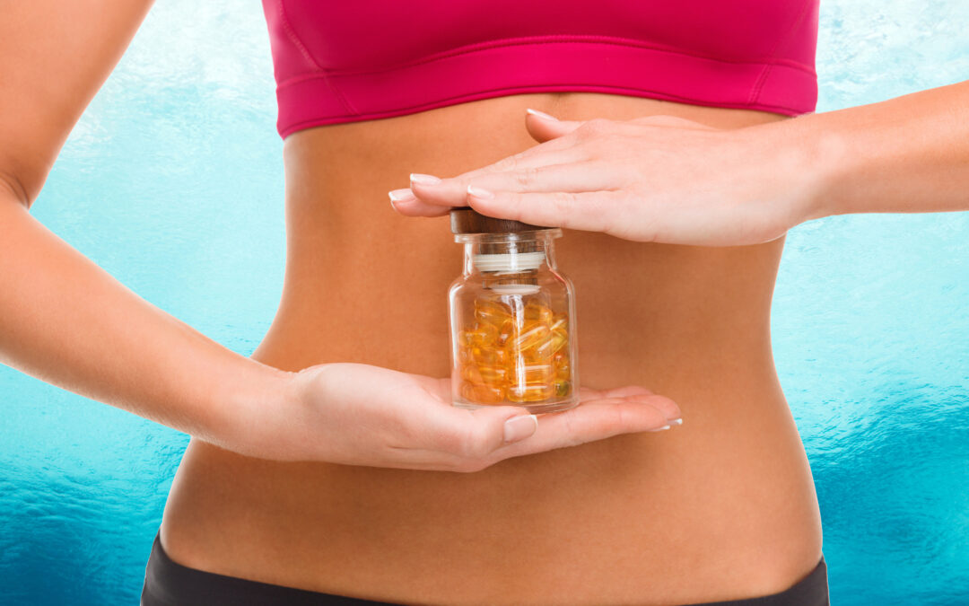A slender woman with a bare midriff holding a bottle of pills to help illustrate Based on BMI When is Surgery Better Than Weight Loss Pills?
