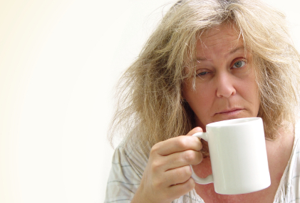Tired-looking woman with a mug of coffee to illustrate ways to boost energy without caffeine