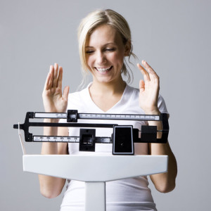 Woman on a scale is delighted what she sees as part of Bariatric Surgery for Sustainable Weight Loss.